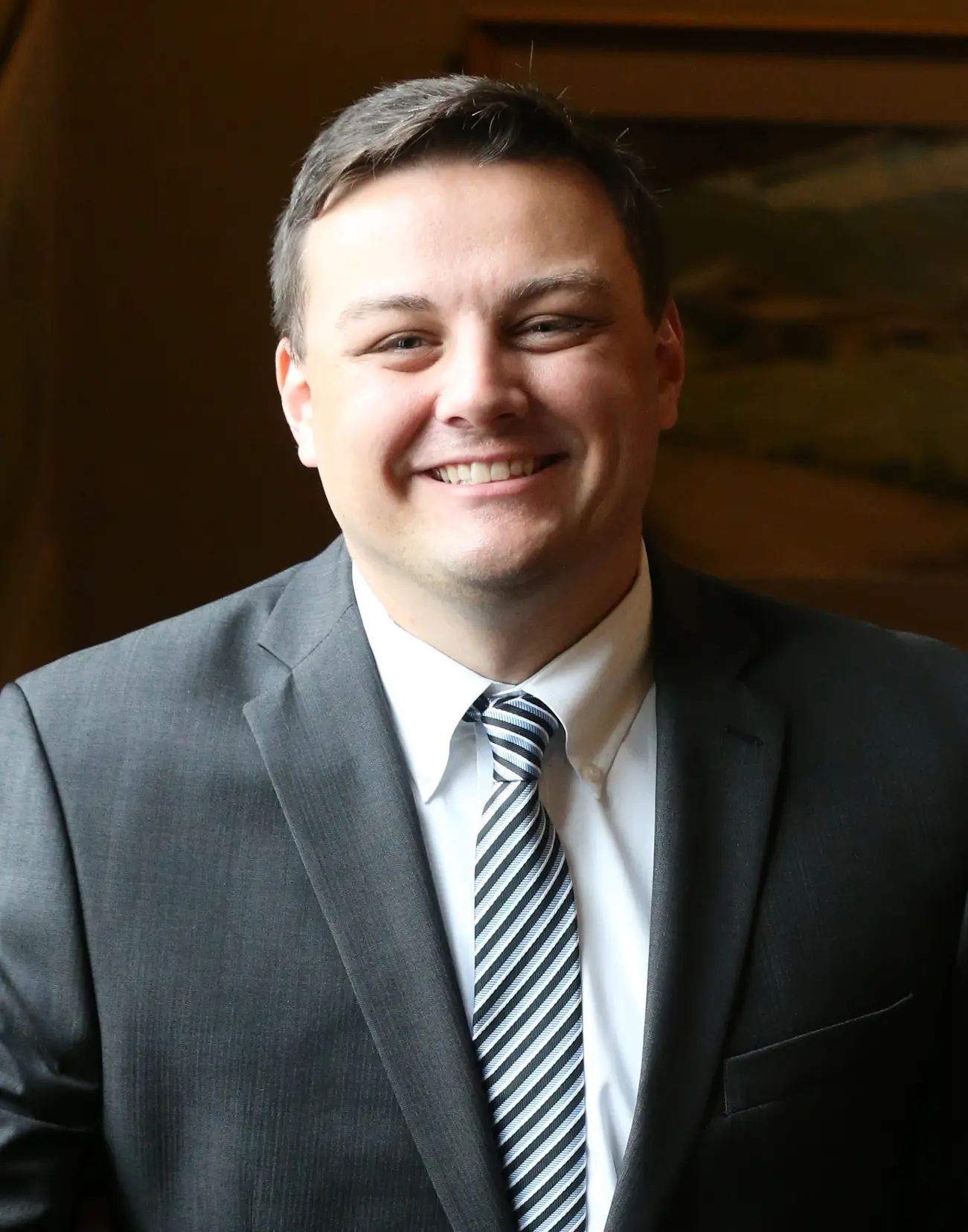 A man smiling, wearing a gray suit jacket and a striped necktie. Evan Fischer of Hoyt Sherman Place.